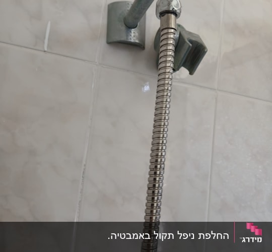 צינור מתכת מחובר לקיר בחדר אמבטיה
